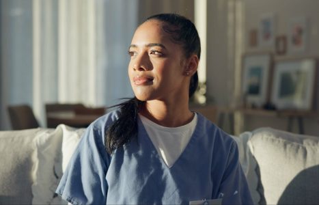 Calm, thinking and a nurse or woman on the sofa to relax from a career in healthcare in a house. Smile, peace and a medical employee or doctor with an idea or vision on the couch for a memory