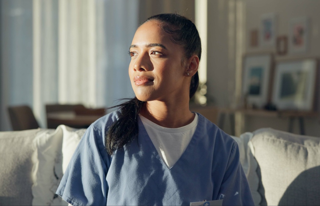 Calm, thinking and a nurse or woman on the sofa to relax from a career in healthcare in a house. Smile, peace and a medical employee or doctor with an idea or vision on the couch for a memory